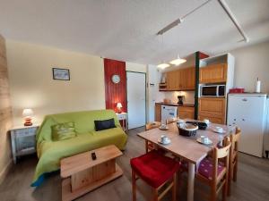 salon z zieloną kanapą i stołem w obiekcie Appartement cosy 3 pièces avec 2 balcons, lave-vaisselle, lave-linge, à proximité des pistes - FR-1-353-126 w mieście La Plagne Tarentaise