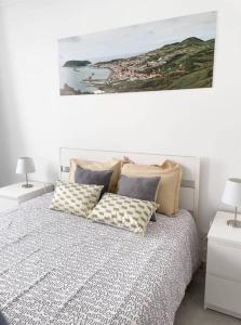 a bedroom with a bed with pillows and a painting at Uma horta na Horta in Horta