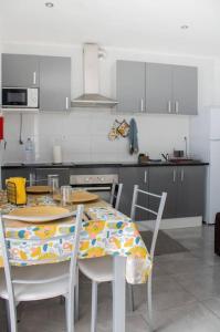 a kitchen with a table and chairs in a kitchen at Aligus 2 Uma Horta na Horta, Faial, Açores in Horta