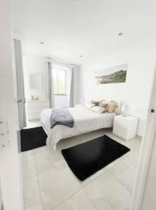 a white bedroom with a bed and a window at Uma horta na Horta in Horta +5 photos