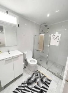 a white bathroom with a toilet and a shower at Uma horta na Horta in Horta