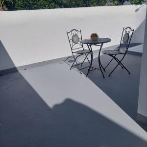 two chairs and a table on a patio at Uma horta na Horta in Horta