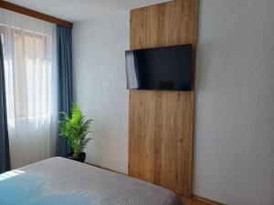 a bedroom with a flat screen tv on a wall at "Уютен дом за Вашето семейство" Сандански, Поленица in Sandanski