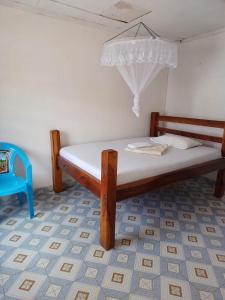 a wooden bed in a room with a blue floor at Kokotoni Garden hotel Tezo 