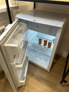 an open refrigerator with two jars of honey at Moncerat in Šiauliai