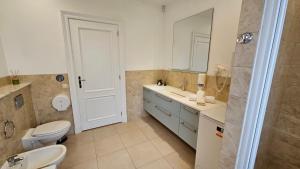 a bathroom with a toilet and a sink and a mirror at Vila Bianca in Inturkė