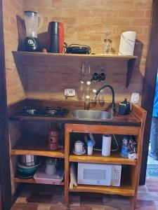 Chalés das cerejeiras في سانتو أنطونيو دو بينهال: مطبخ مع حوض وطاولة عمل