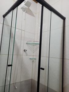 Chalés das cerejeiras في سانتو أنطونيو دو بينهال: دش مع أبواب زجاجية ورف زجاجي