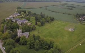una vista aérea de un antiguo castillo en un campo verde en Cockayne Hatley Hall, en Cockayne Hatley