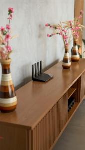 three vases with flowers on a wooden table at Lake's House - Piscina natural aquecida in Socorro +37 photos