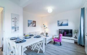 a white dining room with a white table and pink chair at Stunning Home In Royan With Wifi in Royan