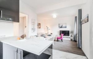 a kitchen and living room with white counters and a pink chair at Stunning Home In Royan With Wifi in Royan +16 photos