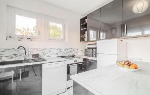 a white kitchen with a bowl of fruit on a counter at Stunning Home In Royan With Wifi in Royan