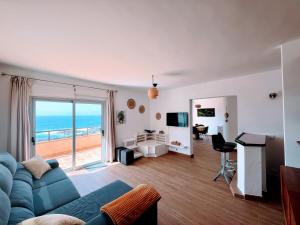 a living room with a blue couch and a view of the ocean at Terraza con vistas al mar Tenerife Norte Mesa del Mar in Tacoronte