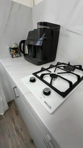 a stove top with a coffee pot on top of it at Grey & White Apart in Vinnytsya +10 photos