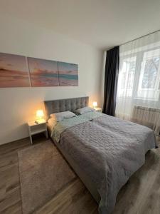 a bedroom with a large bed and two lamps at Grey & White Apart in Vinnytsya
