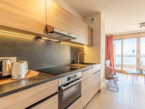 eine Küche mit Spüle und Herd in der Unterkunft Duplex cosy avec piscine et spa, pied des pistes - FR-1-461A-25 in Arc 1600