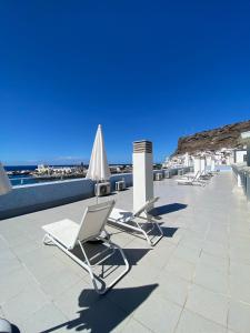 a row of lounge chairs sitting on a roof at Amazónico Playa de Mogán in Puerto de Mogán
