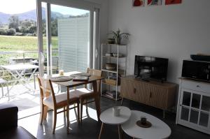 a living room with a table and chairs and a television at Gîtes Jara et Mendia, Maison Eguzki-Lore, Saint-Jean-Pied-de-Port, Pays Basque in Saint-Jean-Pied-de-Port