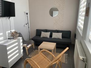 a living room with a couch and a table at Le logis de la Marina in Calais