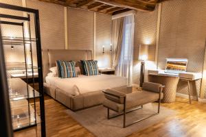 a bedroom with a bed and a chair and a desk at LE RÊVE DE NAIM Roma in Rome