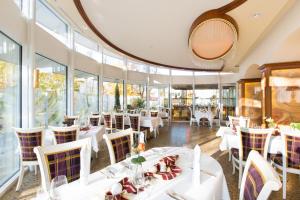 a restaurant with white tables and chairs and windows at AKZENT Hotel Restaurant Altdorfer Hof in Weingarten