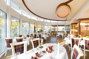 un ristorante con tavoli e sedie bianchi e finestre di AKZENT Hotel Restaurant Altdorfer Hof a Weingarten