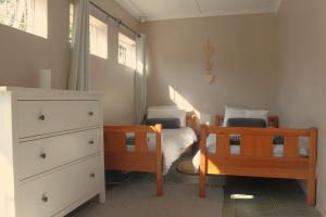 a small bedroom with two beds and a dresser at Fever Tree Cottage in Winston Park +19 photos