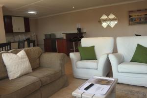 a living room with a couch and two chairs at Fever Tree Cottage in Winston Park