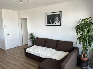 a living room with a couch and potted plants at Highrise in Shoreditch in London