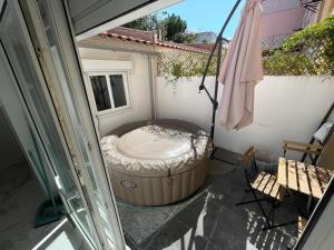 un patio esterno con vasca e ombrellone di Queluz Maison Jacuzzi Escape a Queluz