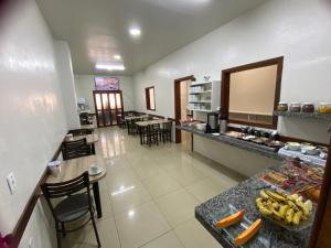 a kitchen with a counter and some tables and chairs at Hotel Três Passos - Prox ao Aeroporto e Rodoviária in Porto Alegre
