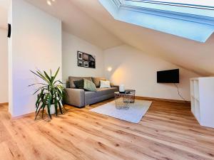 a living room with a couch and a tv at Apartment Mirador an der Hohen Wand in NÖ in Grünbach am Schneeberg