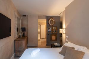 a bedroom with a white bed and a mirror at Iseo Escape - Charm Studio in the Heart of the City in Iseo