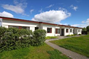 a white building with a grassy yard in front of it at Eldá apartments in Myvatn