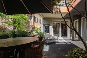 an outdoor patio with a wooden table and chairs at Iseo Escape - Charm Studio in the Heart of the City in Iseo