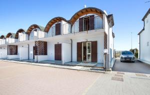 a white building with an archway in a parking lot at Casa Chappell in Badolato