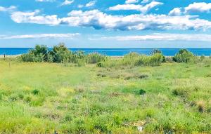 a field of grass with the ocean in the background at Casa Chappell in Badolato +9 photos