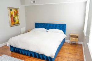 a bed with a blue headboard in a bedroom at 12ppl House in NW BBQ & Fire Pit in Washington