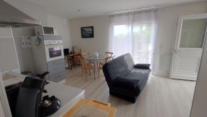 a living room with a black couch and a table at WELCOME Logement avec terrasse proche Bordeaux in Saint-André-de-Cubzac