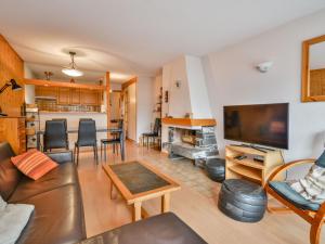 a living room with a couch and a tv at Bel appartement 2 chambres près des pistes, centre station, parking, WIFI, balcon exposé sud - FR-1-684-11 in Morzine