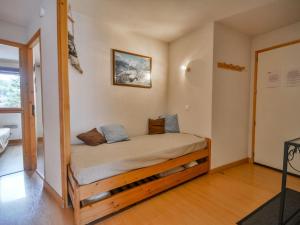 a bed in a room with a wooden frame at Bel appartement 2 chambres près des pistes, centre station, parking, WIFI, balcon exposé sud - FR-1-684-11 in Morzine