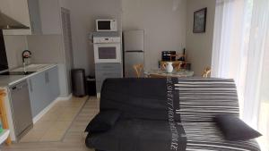a living room with a couch and a kitchen at WELCOME Logement avec terrasse proche Bordeaux in Saint-André-de-Cubzac
