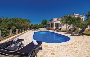 a swimming pool with two lounge chairs and a house at Lovely Apartment In Barbat With Wifi in Barbat na Rabu
