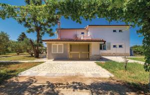 a house with a garage in front of it at Lovely Apartment In Barbat With Wifi in Barbat na Rabu +30 photos