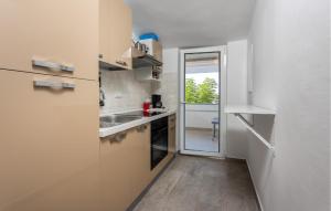 a small kitchen with a sink and a refrigerator at Lovely Apartment In Barbat With Wifi in Barbat na Rabu