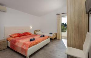 a bedroom with a bed with red pillows and a window at Lovely Apartment In Barbat With Wifi in Barbat na Rabu