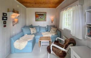 a living room with a blue couch and a table at Cozy Home In Sjusjøen With Sauna in Sjusjøen