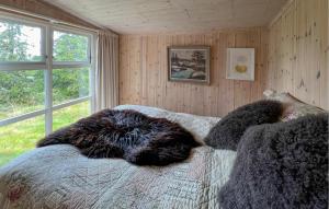 a bedroom with a bed with blankets and a window at Cozy Home In Sjusjøen With Sauna in Sjusjøen +11 photos