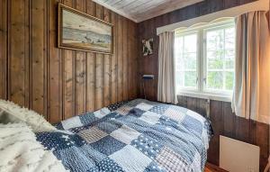 a bedroom with a bed with a blue and white quilt at Cozy Home In Sjusjøen With Sauna in Sjusjøen
